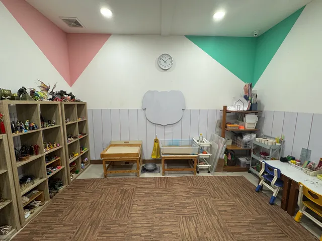 Playroom with toy shelves, small tables, and pastel wall decorations