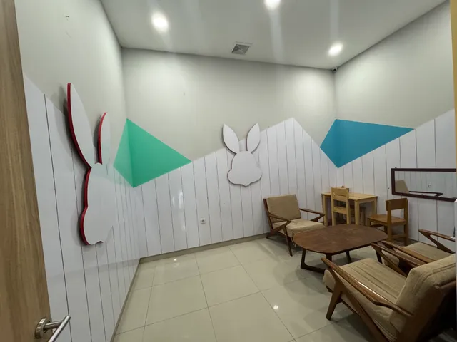 Wooden chairs and tables beside rabbit-shaped wall decorations