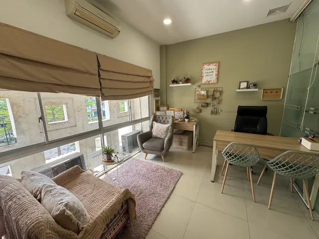 Room with windows, a desk, chairs, and a sofa