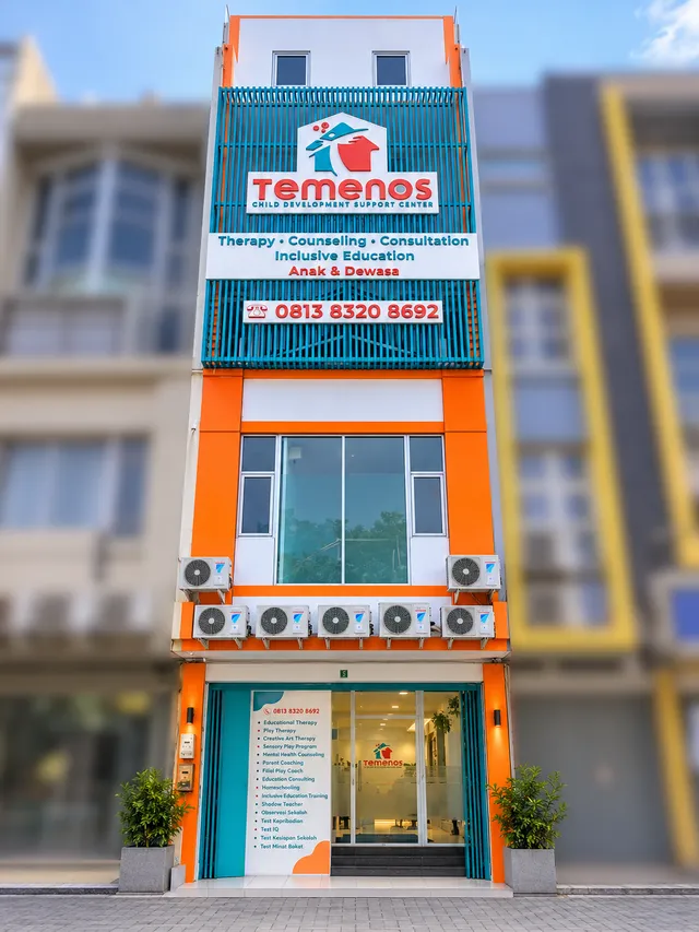 Multistory Temenos building with a sign and an orange entrance