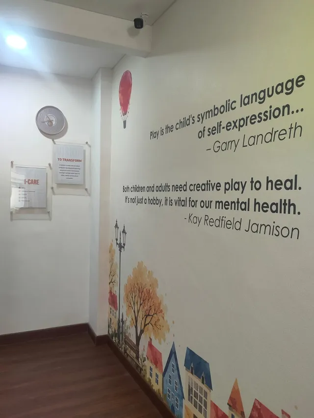 Wall with quotations about play, house and tree decorations, and framed Temenos vision and values